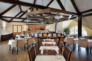 een eetkamer met tafels en stoelen in een kamer met plafonds bij Sagadi Manor Hotel in Sagadi