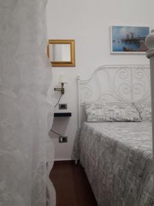a bedroom with a bed and a white wall at La Stanza a parte in Naples