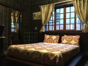 a bedroom with a bed in a room with windows at Westmoreland Lodge in Johannesburg