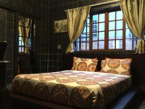 1 dormitorio con 1 cama en una habitación con ventanas en Westmoreland Lodge, en Johannesburgo