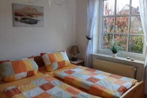 een slaapkamer met 2 bedden en een raam bij Seestern in Werdum