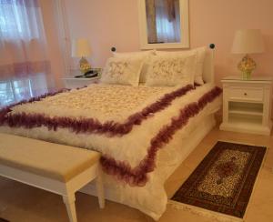 a bedroom with a large white bed with a table at Garni Hotel Helvetia in Belgrade