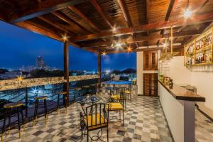 a patio with tables and chairs and a view of the city at Hotel Monaguillo de Getsemaní in Cartagena de Indias