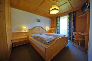a bedroom with a large wooden bed in a room at Pension Arnica B&B in San Vigilio Di Marebbe