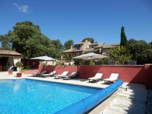 - une piscine avec des chaises et des parasols à côté d'une maison dans l'établissement Gite Le city en Provence, à Lambesc