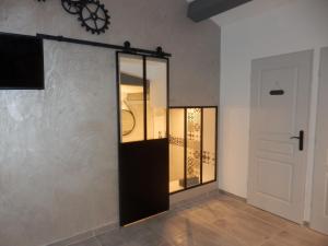 Cette chambre est dotée d'une porte en verre et d'un mur blanc. dans l'établissement Gite Le city en Provence, à Lambesc