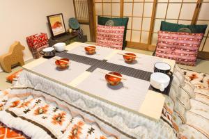 a table with bowls and cups on top of it at City Center 200 Years Old Traditional House Next to 2 Train Lines in Kyoto