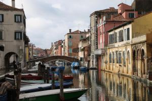 a group of boats in a canal between buildings at B&B Casa Perla in Chioggia