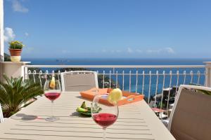 una mesa con dos copas de vino y vistas al océano en Mareluna, en Nerano