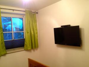 TV de pantalla plana en una pared junto a una ventana en Apartment Gschwandtner Haus Stoareich en Bad Gastein