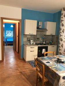 una cucina con tavolo e parete blu di Casa Vacanza Blue Sea a San Vito lo Capo