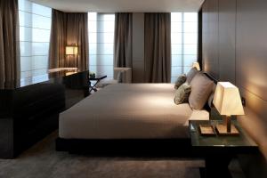 a hotel room with a large bed and a table at Armani Hotel Milano in Milan