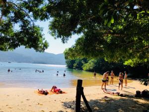 a group of people swimming in the water on a beach at Praia da Crena in Abraão