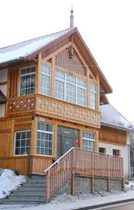 a large wooden house with a porch and stairs at U Musa in Karpacz