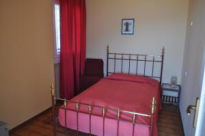 a bedroom with a bed and a chair and a window at Holiday home near Monte Baldo in Tremosine Sul Garda in Tremosine Sul Garda