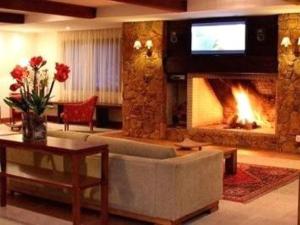 uma sala de estar com um sofá e uma lareira em Apart-hotel em Gramado, padrão 4 estrelas, no centro em Gramado