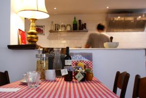 ラーリオにあるVilla Albonicoの赤白の縞模様のテーブルクロス付テーブル