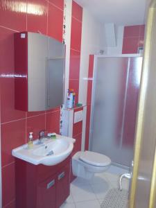 een rode badkamer met een toilet en een wastafel bij Apartmani Slavica in Makarska