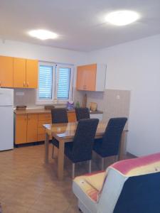 una cucina con tavolo, sedie e frigorifero di Apartmani Slavica a Makarska