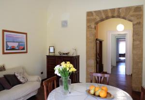 a living room with a table with a vase of flowers at La Casa Di Tufo in Palermo