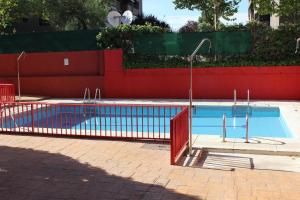 マドリードにあるVivienda Familiar con Jardin junto a Ifemaの赤い柵のスイミングプール