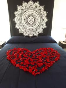 a bed with a heart made out of red roses at Posada Soleil Bed & Breakfast in Valle de Guadalupe