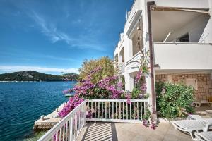 a building with flowers on a balcony next to the water at Repic Apartments in Klek