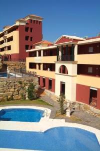 una grande piscina di fronte a un edificio di Apartamentos Turisticos Aureus Bahia Sur a La Línea de la Concepción