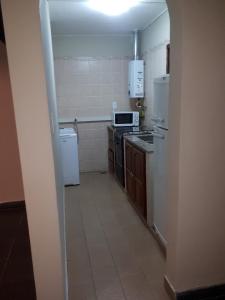 a small kitchen with a stove and a refrigerator at Alquiler Temporario Jujuy 2 in San Salvador de Jujuy