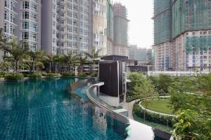 a large swimming pool in a city with tall buildings at HostaHome Suites at 1Medini - Your Ideal Stay Near the Thrills of Legoland in Nusajaya