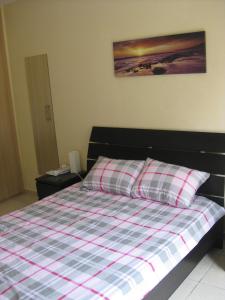 a bedroom with a bed with a checkered blanket at Pyla Village Resort F110 (Apartment near Larnaca) in Pyla