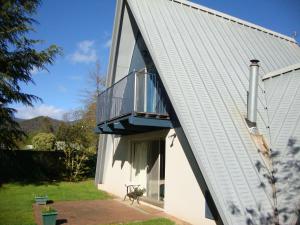 a house with a balcony on the side of it at Ageri Holiday House in Bright