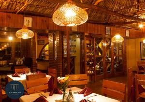 un restaurante con mesas, sillas y lámparas de araña en Hotel Dos Mundos Panajachel, en Panajachel