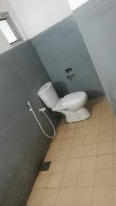 łazienka z białą toaletą w kabinie w obiekcie Friends Paradise w mieście Kilinochchi