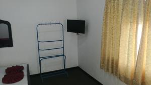 KilinochchiにあるFriends Paradiseのはしご、テレビ、窓が備わる客室です。
