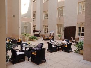 a patio with tables and chairs and a piano at Le Park Hotel in Doha