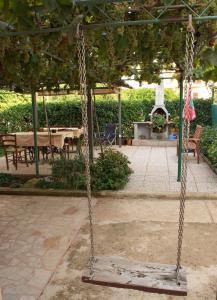 a swing in a garden with a fireplace at Apartments & Rooms BARBARA in Umag
