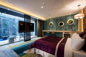 a bedroom with a large bed and a flat screen tv at Shu Jia Motel in Taichung