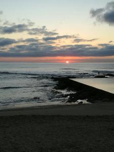 una puesta de sol en una playa con el océano en Holiday unit 54 Eden Dunes, en Shelly Beach
