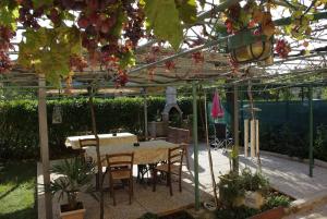 a patio with a table and chairs under a pergola at Apartments & Rooms BARBARA in Umag