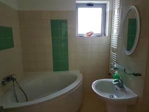 a bathroom with a tub and a sink at Apartments For You in Olimp +27 photos