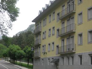 a yellow building with balconies on the side of a street at Albergue Turístico Rio Aragon in Canfranc-Estación