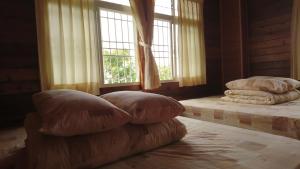 1 dormitorio con 2 almohadas en una cama con ventana en An Yun Mountain Homestay en Meishan
