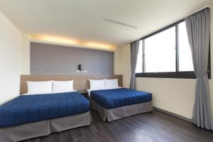 ein Krankenhauszimmer mit 2 Betten und einem Fenster in der Unterkunft Bulowan Hotel in Hualien