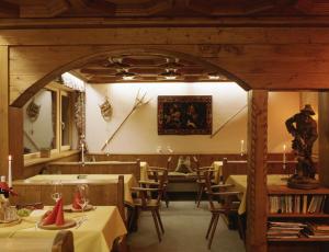 a restaurant with tables and chairs and a person in the background at Hotel Garni Ernst Falch in Sankt Anton am Arlberg +22 photos
