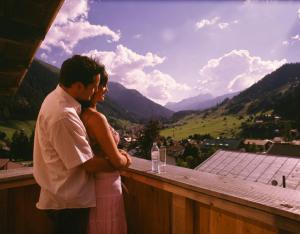 a man and woman standing on a balcony with a view at Hotel Garni Ernst Falch in Sankt Anton am Arlberg