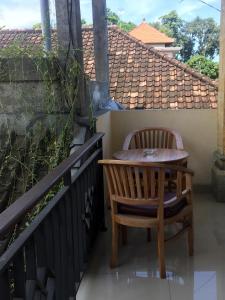 a small table and chairs on a balcony at Bagus Homestay in Ubud