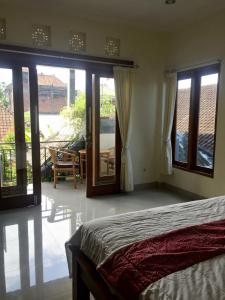 1 dormitorio con cama y vistas a un patio en Bagus Homestay, en Ubud