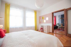 um quarto com uma grande cama branca e uma sala de estar em Spacious Stylish Apartment in Old Town em Sibiu