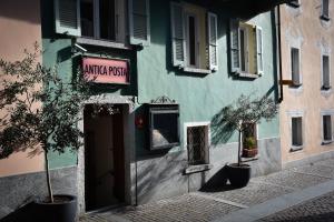 un bâtiment vert avec une porte dans une rue dans l'établissement Boutique-Hotel Antica Posta, à Ascona